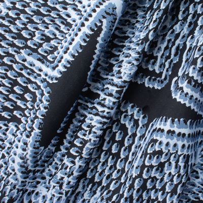 Pilot River fabric displaying scaled-up flame-like marks in blue on cotton-linen