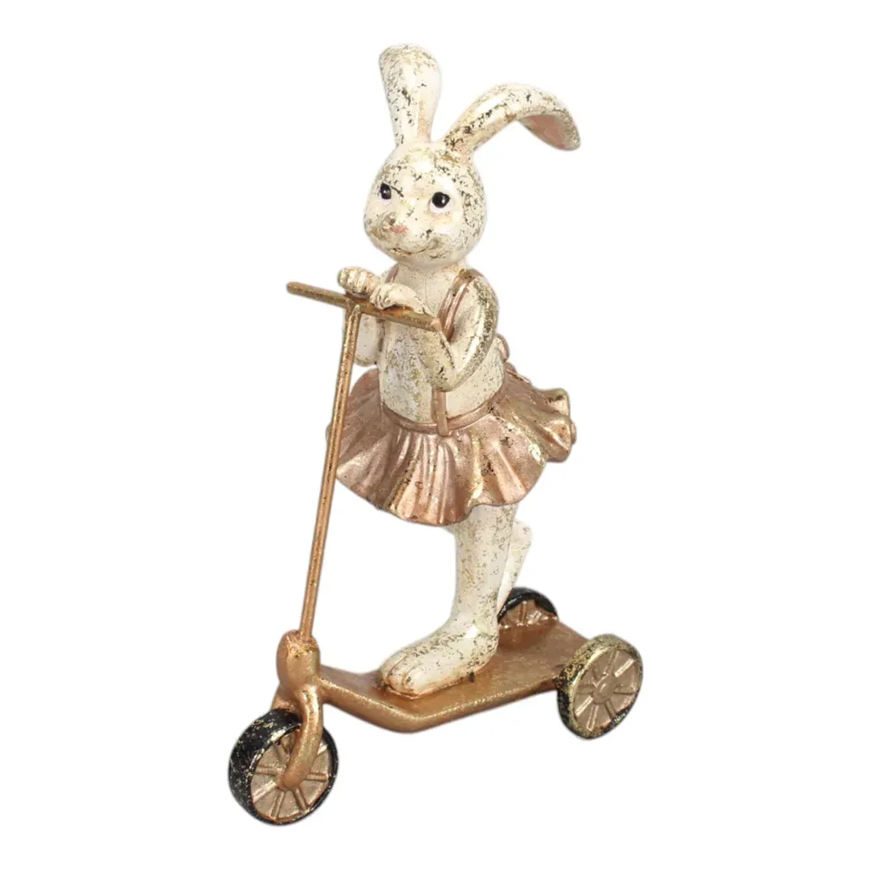 Hasenfigur, Kaninchen auf Tretroller, 16 cm, mit roségoldfarbenem Rock Hasenfigur aus Kunstharz, 16 cm, mit roségoldfarbenem Rock auf einem Tretroller