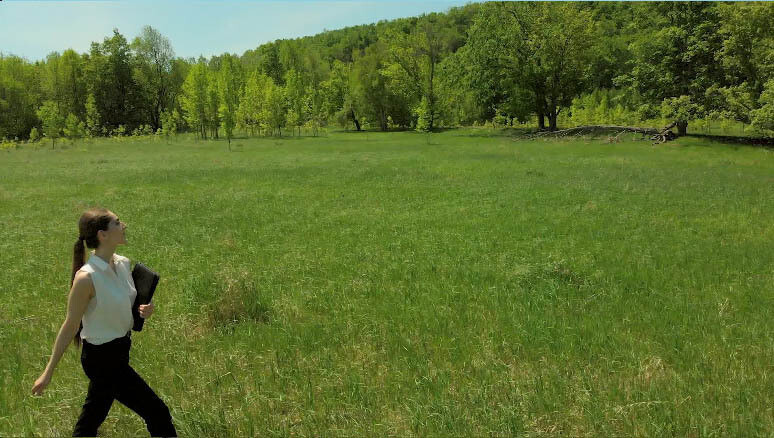Young Woman walks and twirls in sunny field holding office book. (3) Young Woman walks and twirls in sunny field holding office book. (3)
