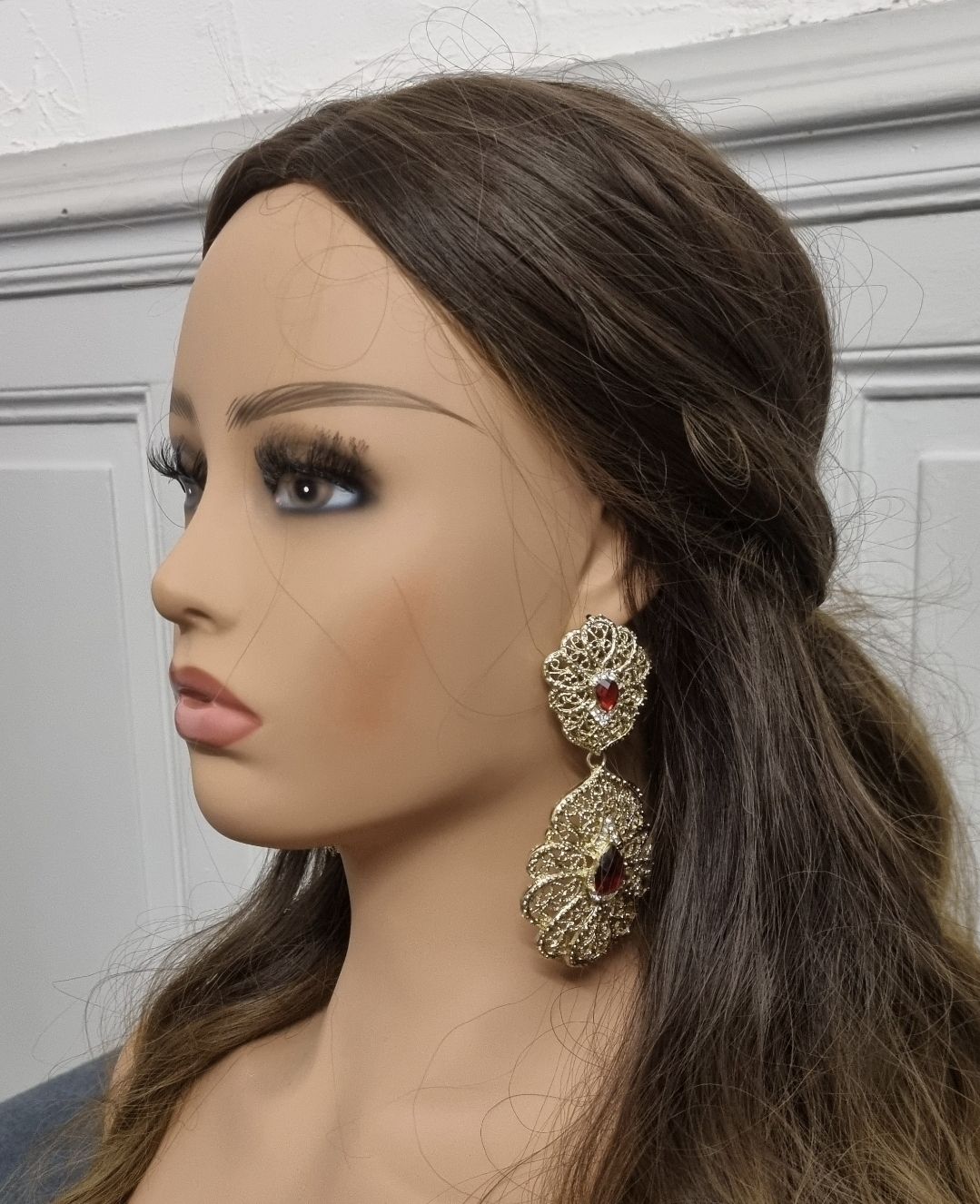 Paire de boucles d'oreilles doré en métal motif filigrané avec pierre rouge Paire de boucles d'oreilles doré en métal motif filigrané avec pierre rouge