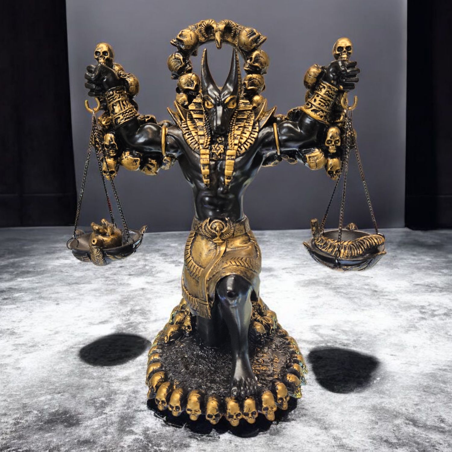 Anubis statue holding golden scales of judgement, kneeling with heart and feather symbols, hand-painted in black and gold.