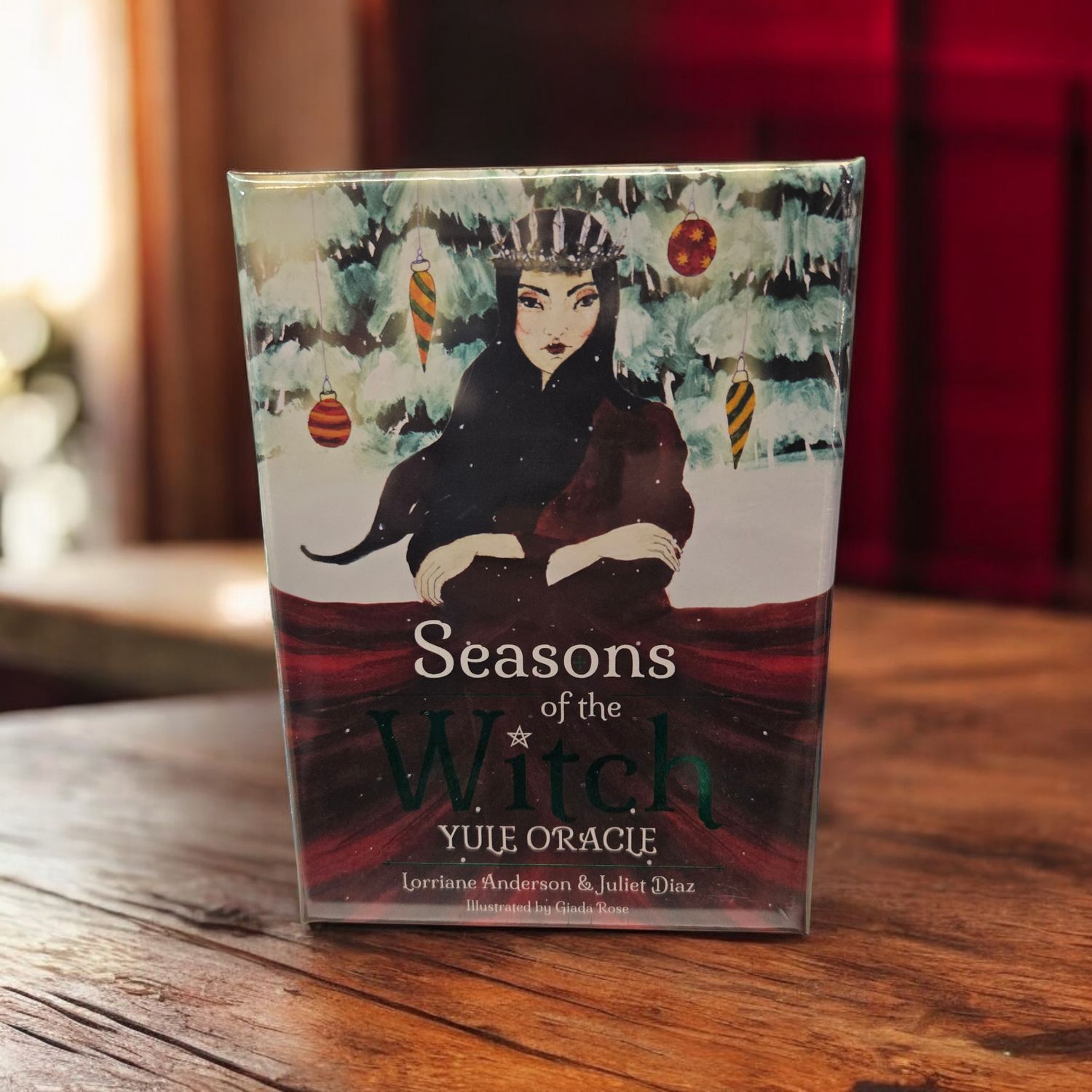 Seasons of the Witch Yule Oracle front showing winter goddess artwork with holiday ornaments and snow scene