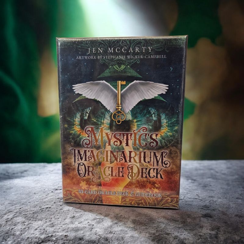 Mystics Imaginarium Oracle deck front with winged key, mystical eyes, and symbolic manifestation artwork