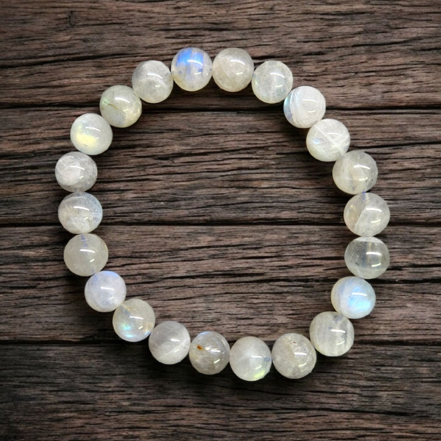 SUNSET LABRADORITE 10MM BRACELET Sunset Labradorite 10mm stretch bracelet with polished iridescent round beads photographed on rustic wooden background