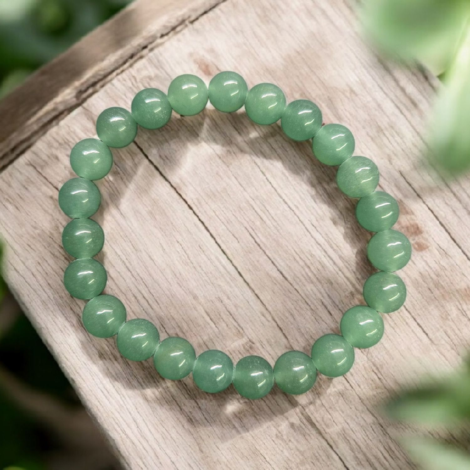 Green aventurine 8mm round bead stretch bracelet displayed on light wooden surface