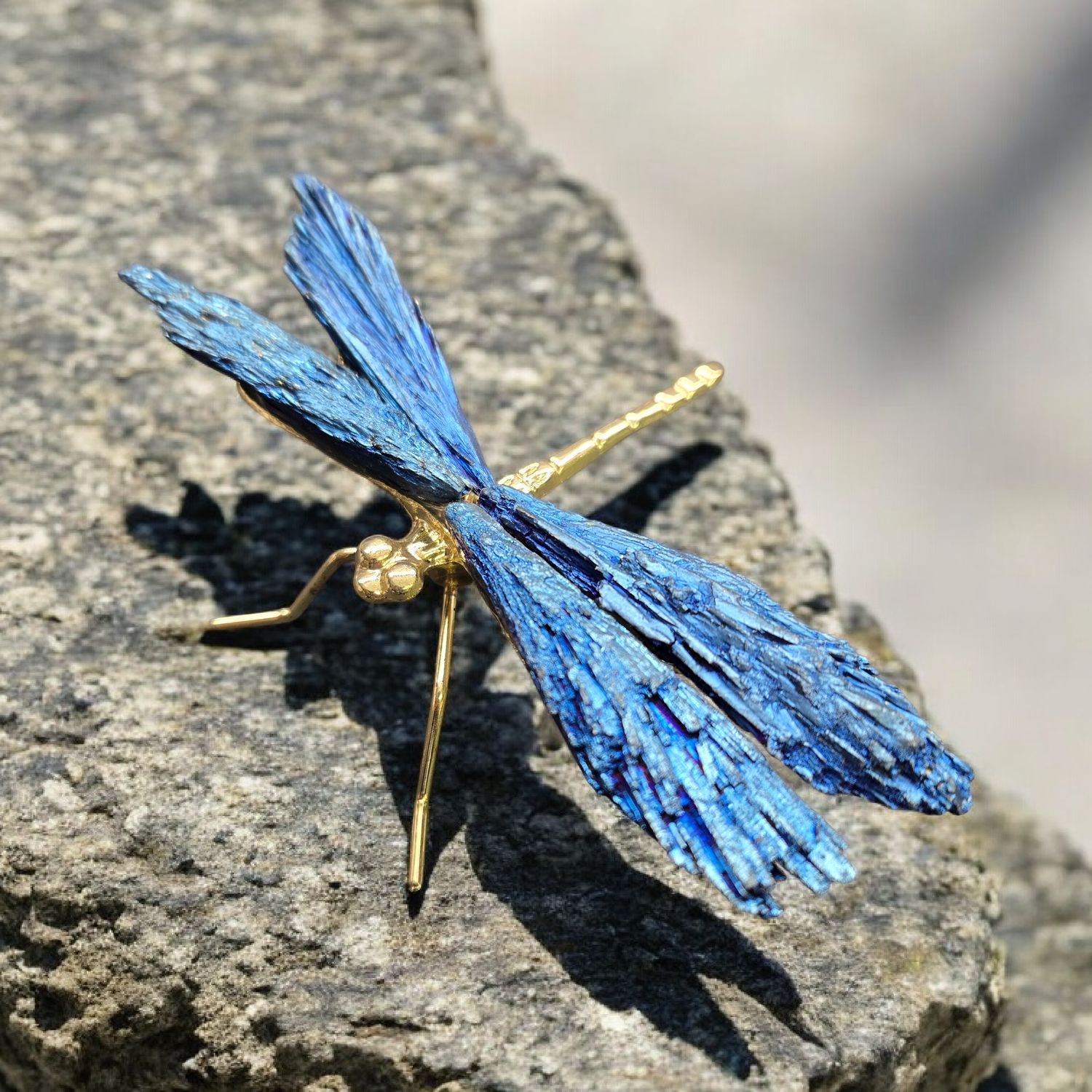 Blue aura kyanite dragonfly with iridescent wings and metallic body