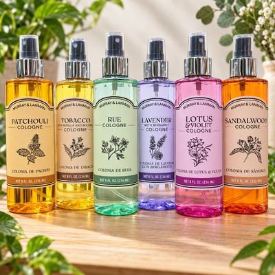 Assorted Murray &amp; Lanman colognes displayed on a light wooden table with greenery.