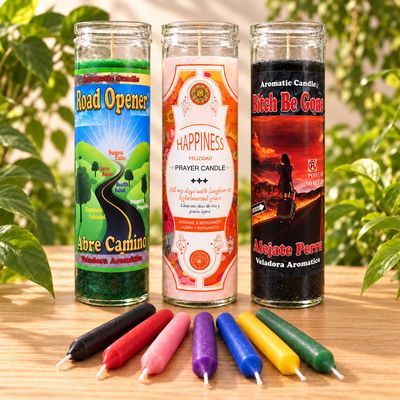 Three ritual candles and colorful chime candles on a wooden table with soft greenery in the background.
