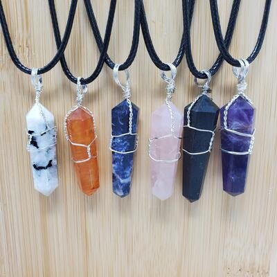 Crystal point pendant necklaces on black cords featuring amethyst, sodalite, rose quartz, and healing stones.