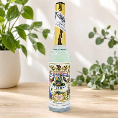 Murray and Lanman Florida Water Cologne 7.50 oz bottle on a light wooden table with greenery.