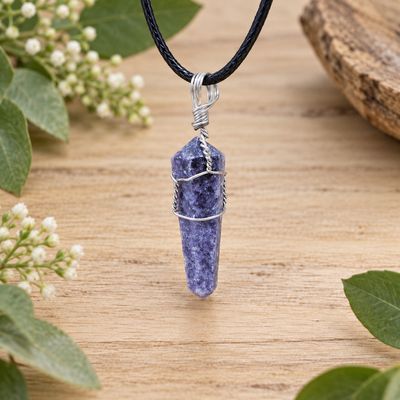 Lepidolite wire wrap point necklace with silver-tone wire and black cord displayed on light wood with greenery.