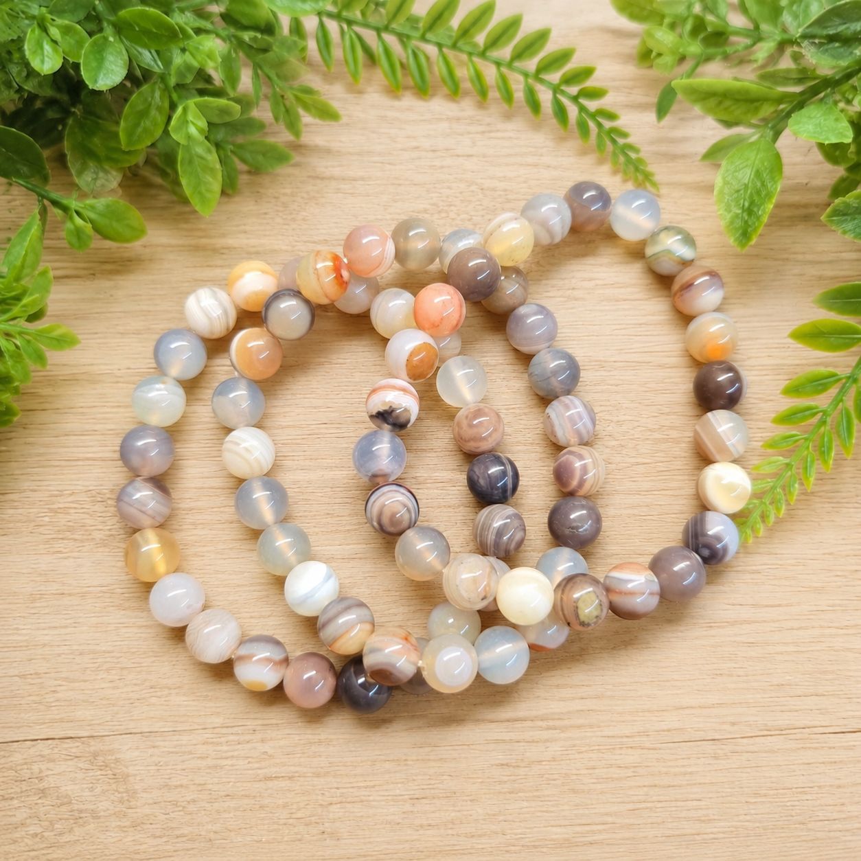 Multiple Botswana Agate 8mm beaded bracelets with gray, peach, cream and lavender banded stones.