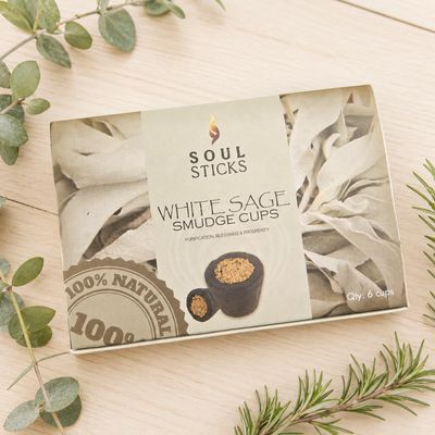 Soul Sticks White Sage Smudge Cups six-pack box displayed on a light wooden table with greenery.
