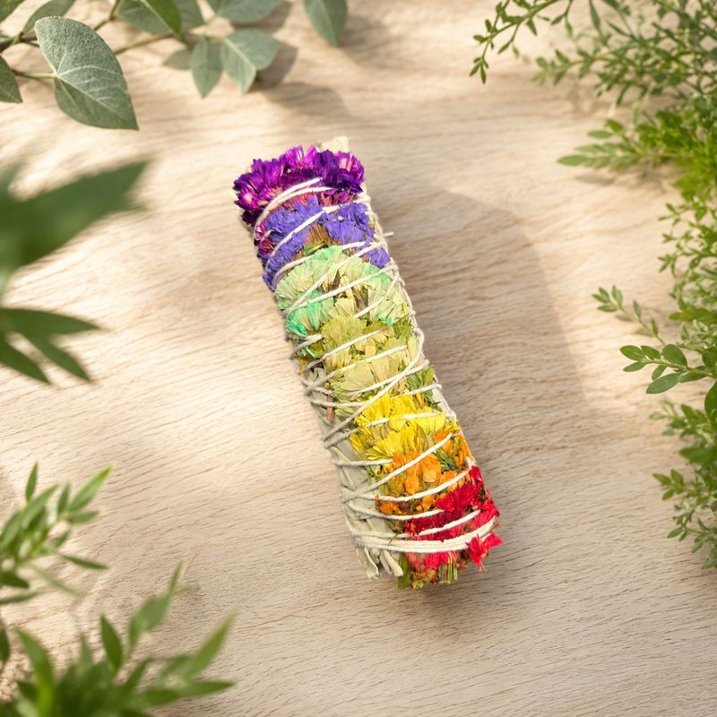Rainbow paperflower sage smudge on a light wooden table with greenery