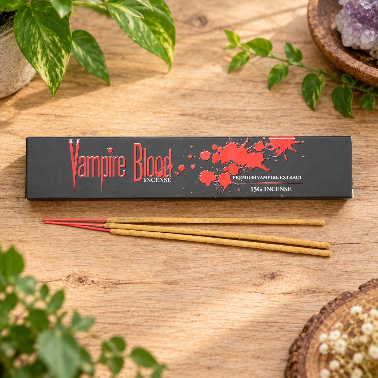 Vampire Blood 15g incense box with incense sticks on a light wooden table with greenery