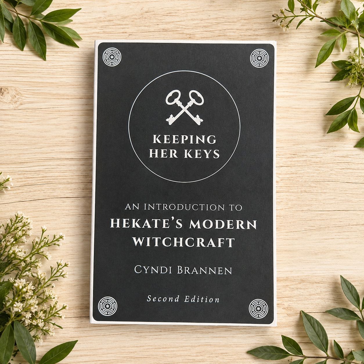 Keeping Her Keys by Cyndi Brannen displayed on a light wooden table with greenery.