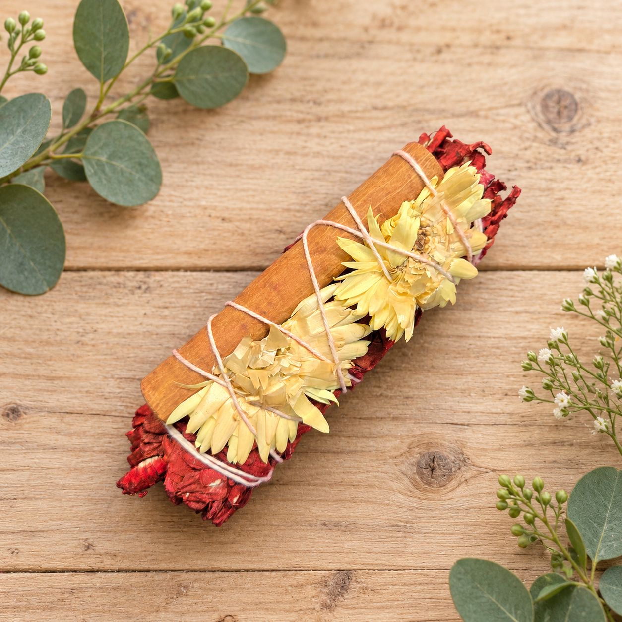 Dragon’s Blood protection and prosperity smudge with white sage, cinnamon and yellow flowers