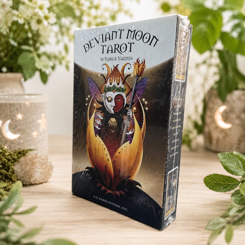 Front of Deviant Moon Tarot deck by Patrick Valenza on wooden table with greenery