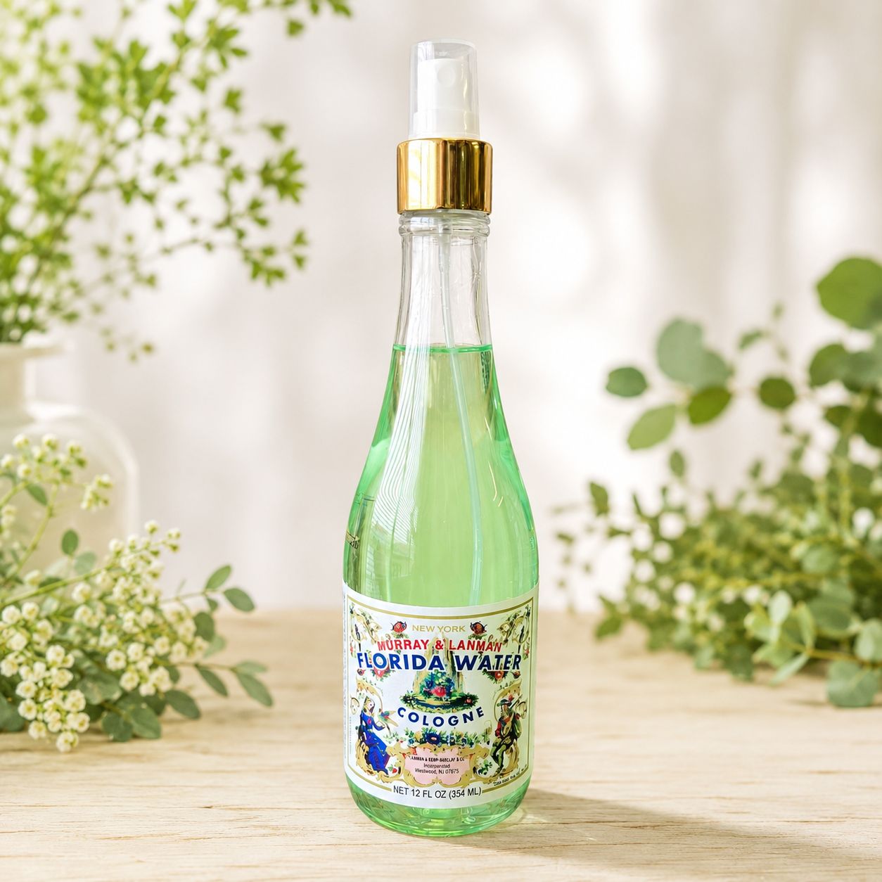 Special Edition Florida Water Cologne 12 oz spray bottle on a light wooden table with greenery.