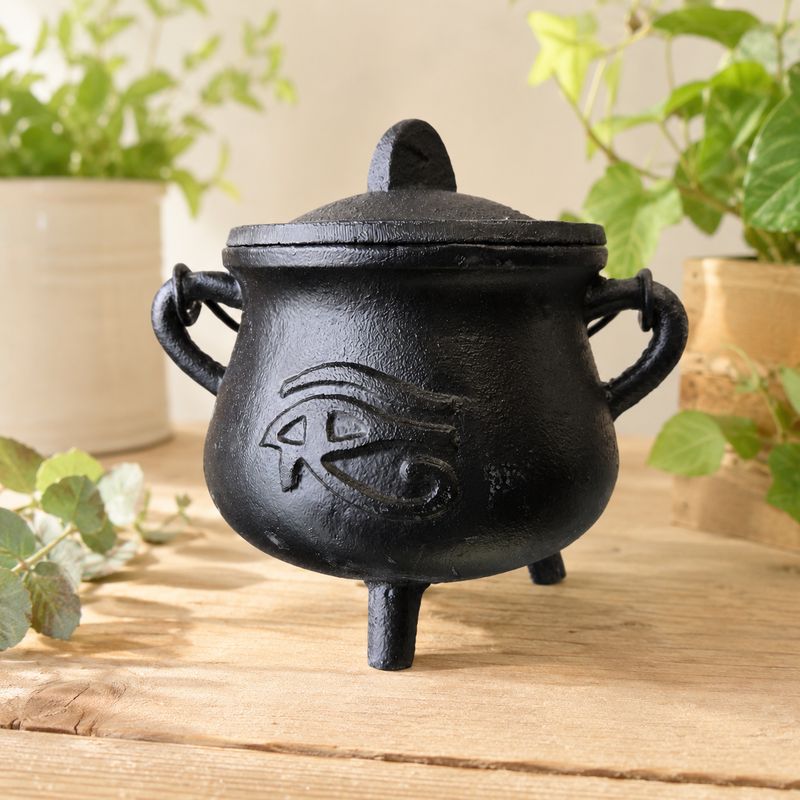 Eye of Horus cast iron cauldron with lid on light wooden altar table at Arkadys Metaphysical Gifts.