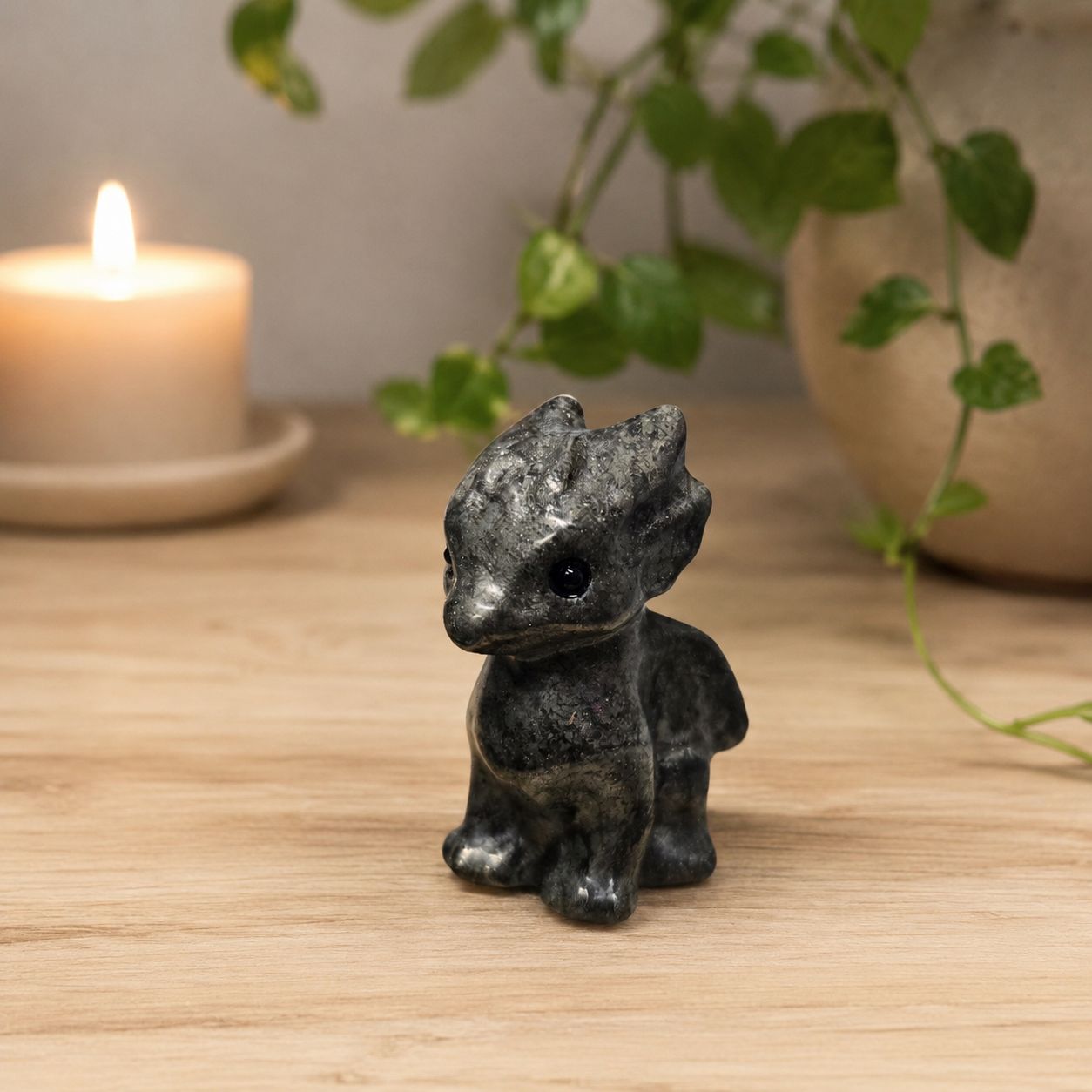 Small pyrite flying dragon carving on light wooden altar scene at Arkadys Metaphysical Gifts.
