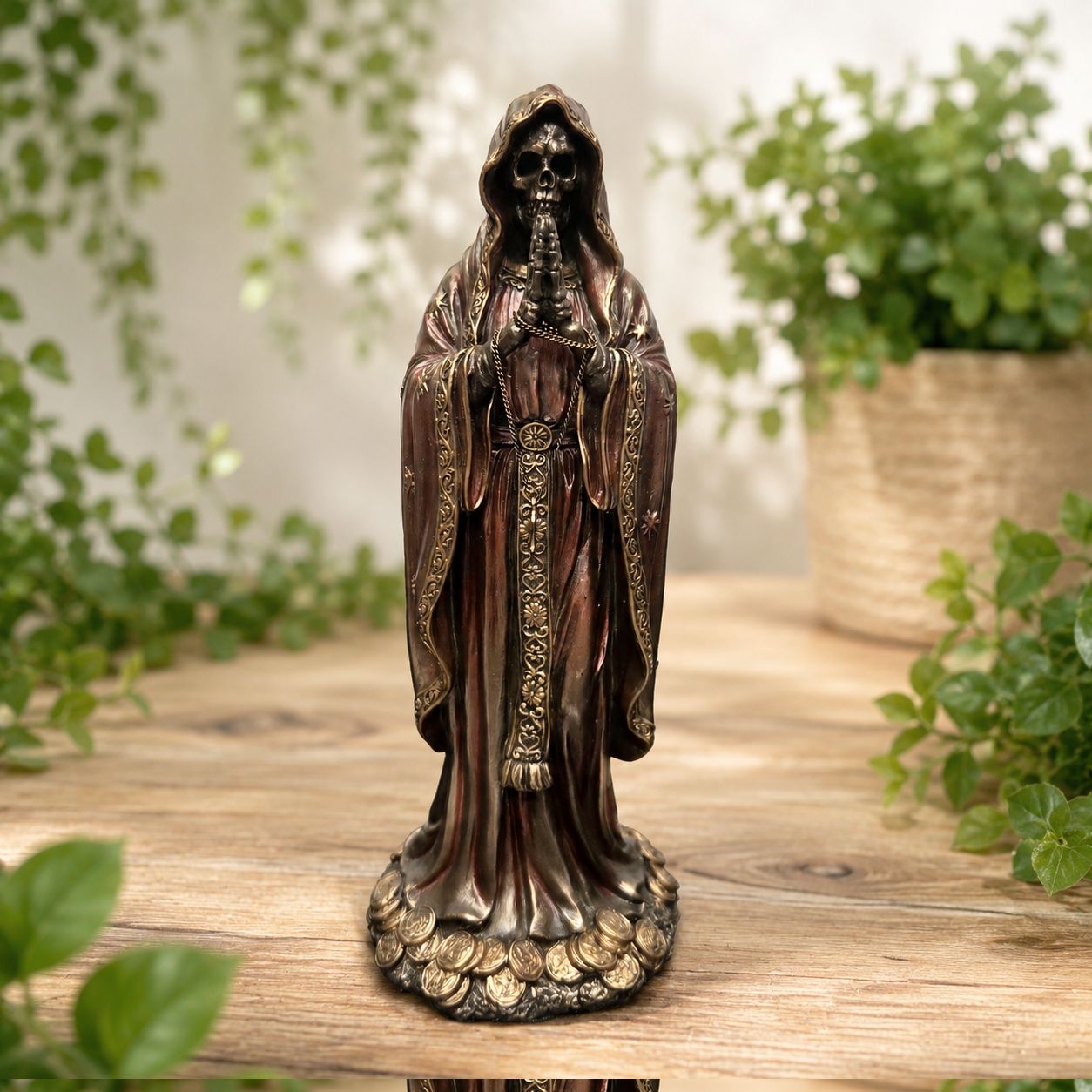 Front of Santa Muerte Rosario Prayer Statue with bronzed robe, rosary, star details, and coin base on wooden table