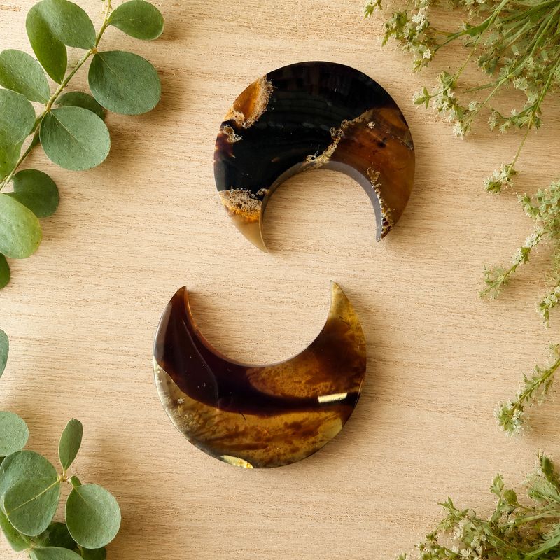 100 percent Natural Amber Moons on light wooden table with greenery