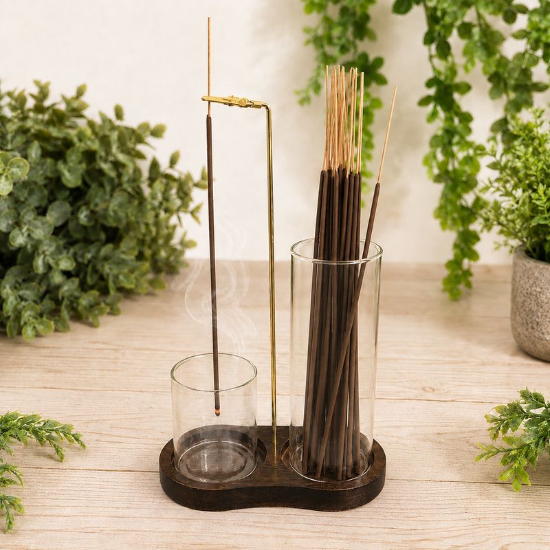 Upside down glass incense burner with lit incense, rising smoke, wood base and incense storage.