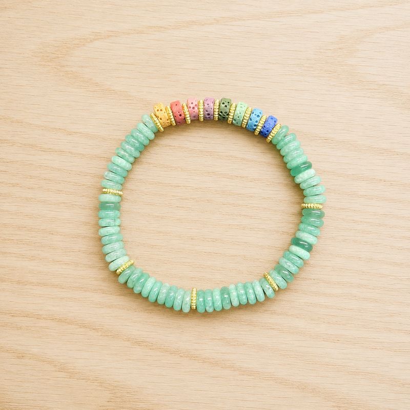 Single chakra volcanic rock green aventurine bracelet displayed on a light wooden table