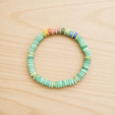 Single chakra volcanic rock green aventurine bracelet displayed on a light wooden table