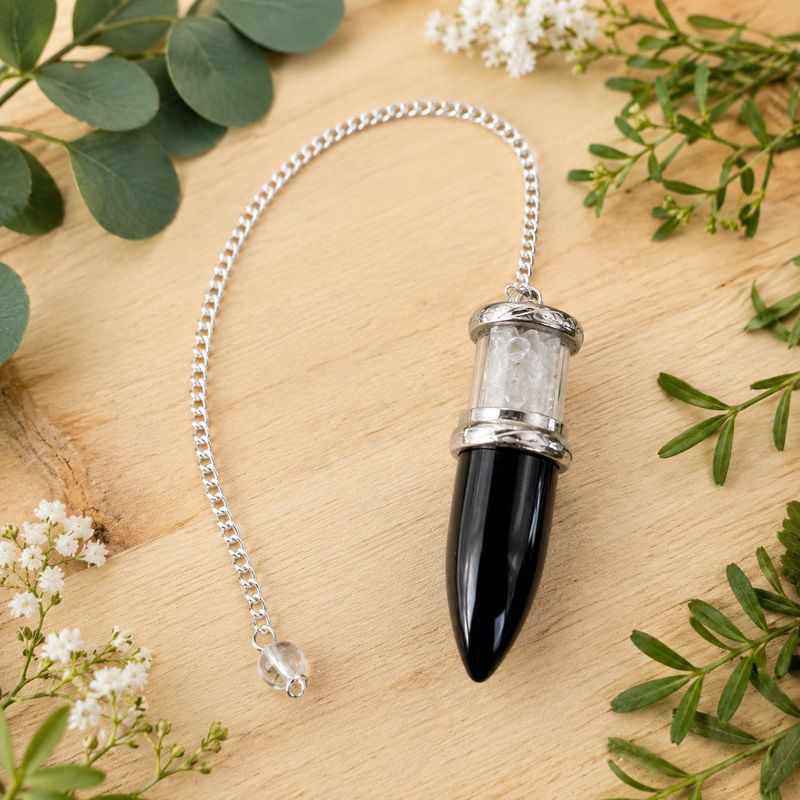 Black Obsidian and Quartz Bullet Chips Pendulum with silver-toned chain on a light wooden table