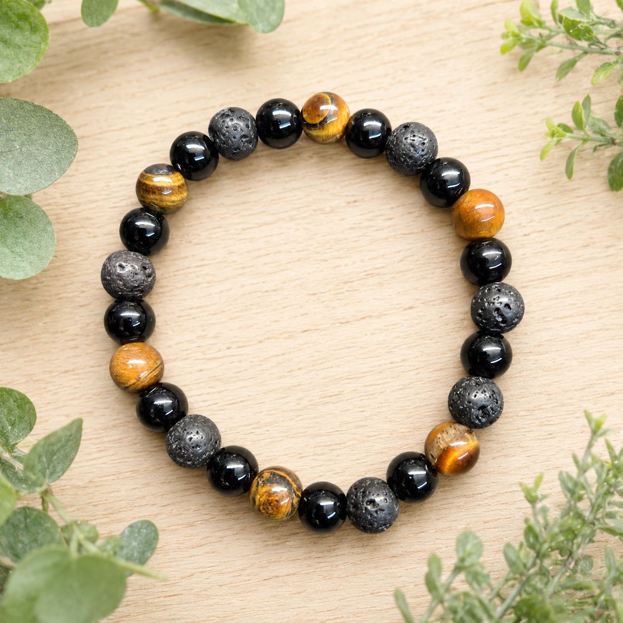 Tiger eye, black obsidian and textured lava stone 8mm stretch bracelet displayed on a wooden table.