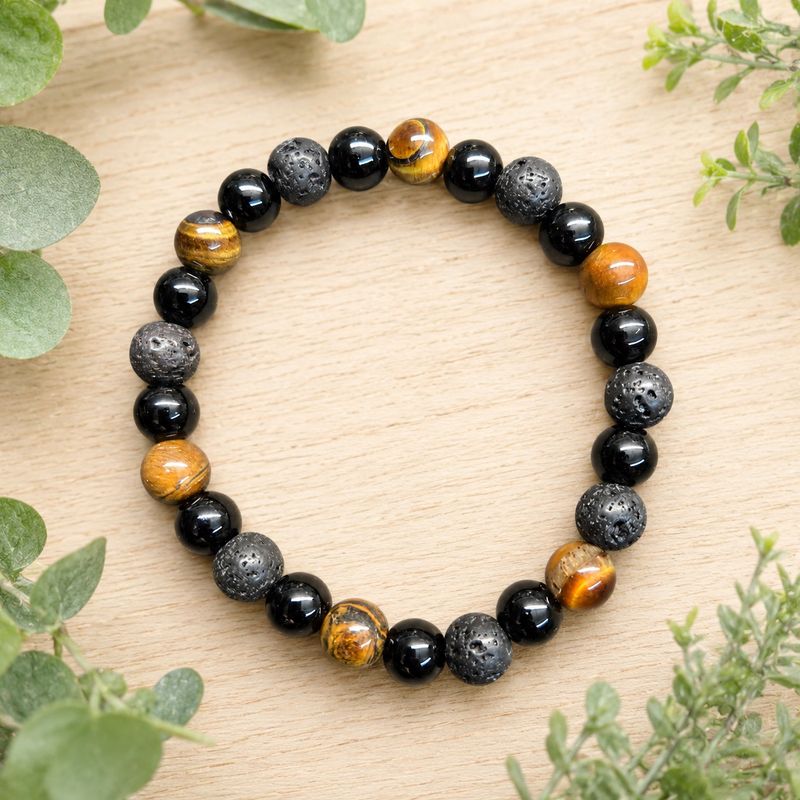 Tiger eye, black obsidian and textured lava stone 8mm stretch bracelet displayed on a wooden table.