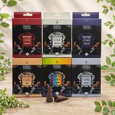 Soul Sticks backflow incense cones in six scents displayed on a light wooden table with greenery.