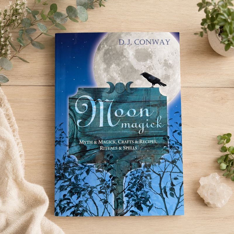 Moon Magick by D.J. Conway displayed on a light wooden table with greenery.
