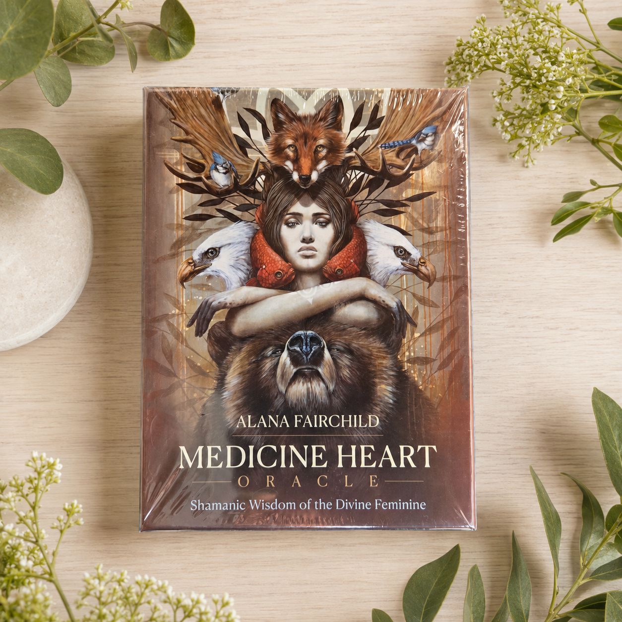 Medicine Heart Oracle by Alana Fairchild displayed on a light wooden table with greenery.