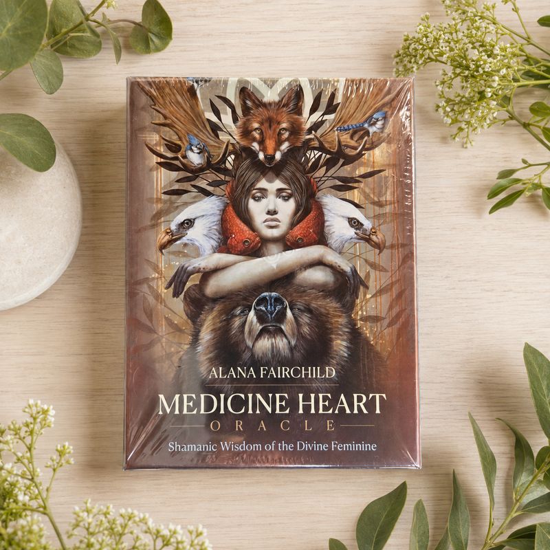 Medicine Heart Oracle by Alana Fairchild displayed on a light wooden table with greenery.