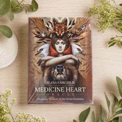 Medicine Heart Oracle by Alana Fairchild displayed on a light wooden table with greenery.