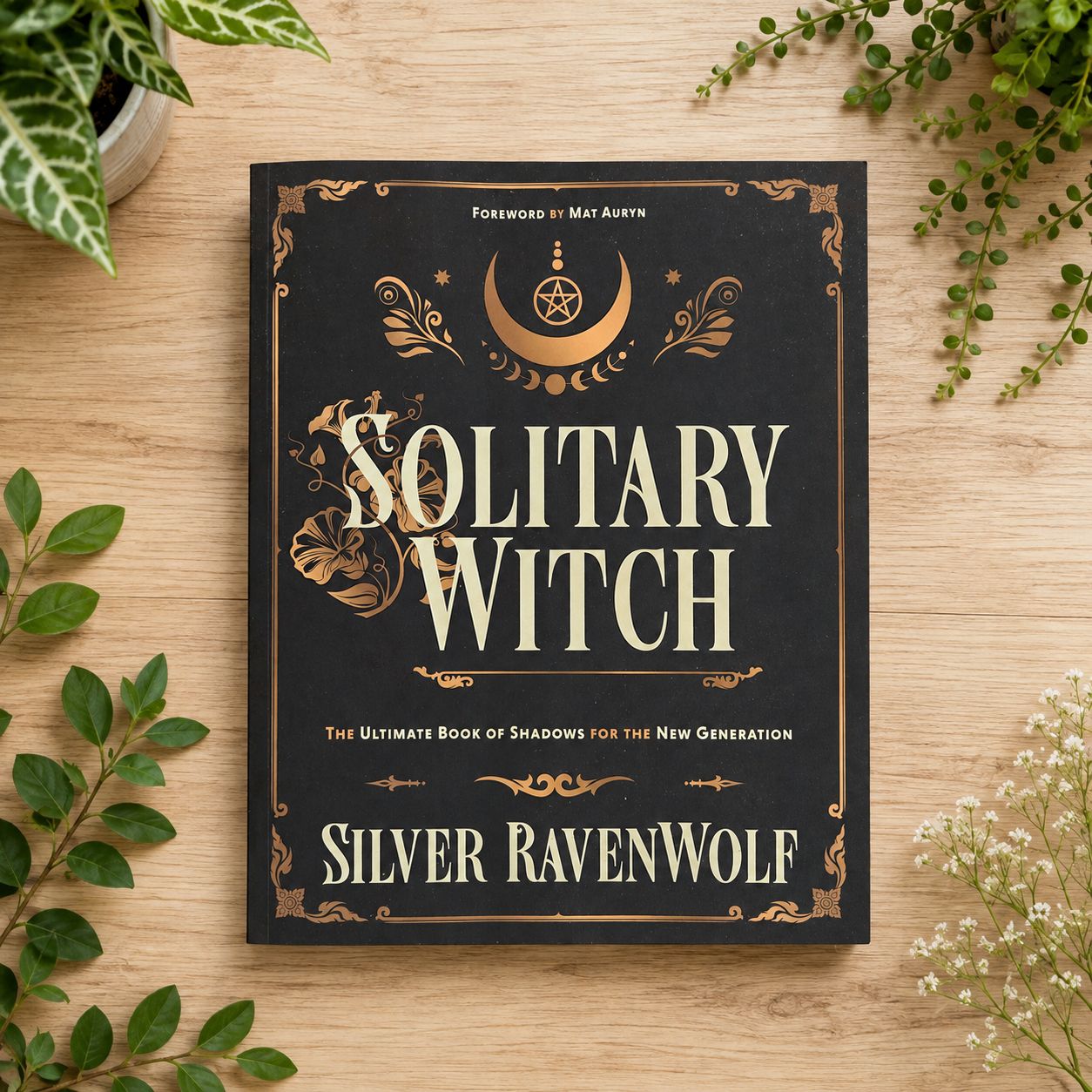 Solitary Witch by Silver RavenWolf displayed on a light wooden table with greenery.