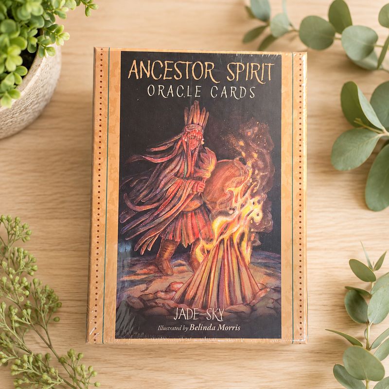 Ancestor Spirit Oracle Cards by Jade-Sky displayed on a light wooden table with greenery.