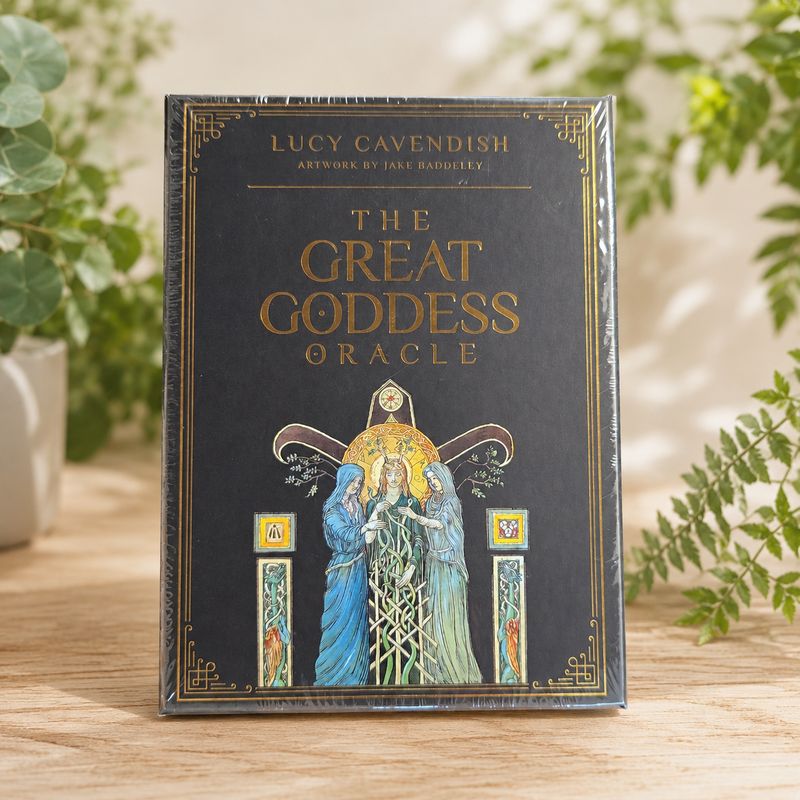 The Great Goddess Oracle by Lucy Cavendish displayed on a light wooden table with greenery.