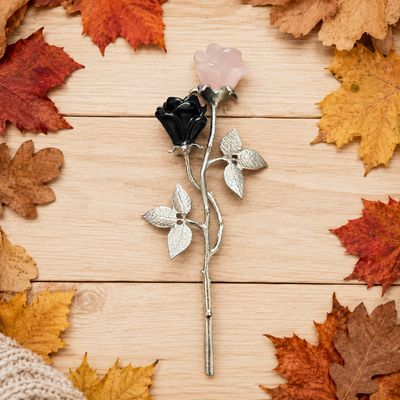 Rose Quartz and Obsidian rose pair on silver-tone stems with leaves displayed on a light wooden table