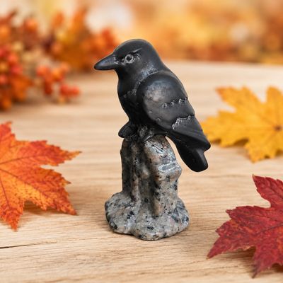 Obsidian raven on Yooperlite tombstone carving displayed with autumn leaves