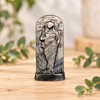 Silver Sheen Obsidian Gaia carving displayed on a light wooden table with greenery