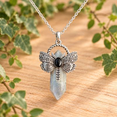 Labradorite dragonfly point necklace with silver-tone pendant and stainless steel chain on light wood with greenery.
