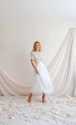 Robe de mariée mi-longue VALENTINA en dentelle avec dos nu inversé, portée dans un décor de mariage, Faith Cauvain