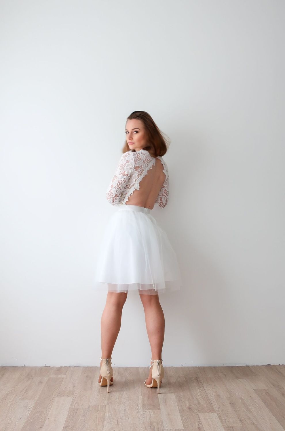 Robe dos nu en dentelle pour mariage civil, jupe tulle courte et manches longues.
