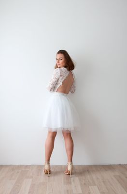 Robe dos nu en dentelle pour mariage civil, jupe tulle courte et manches longues.