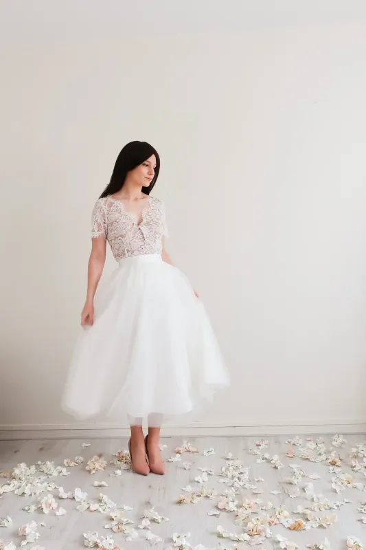 ROSALIA Vue rapprochée d'une robe de mariée en tulle mi-longue, avec un bustier en dentelle délicate et un style bohème.