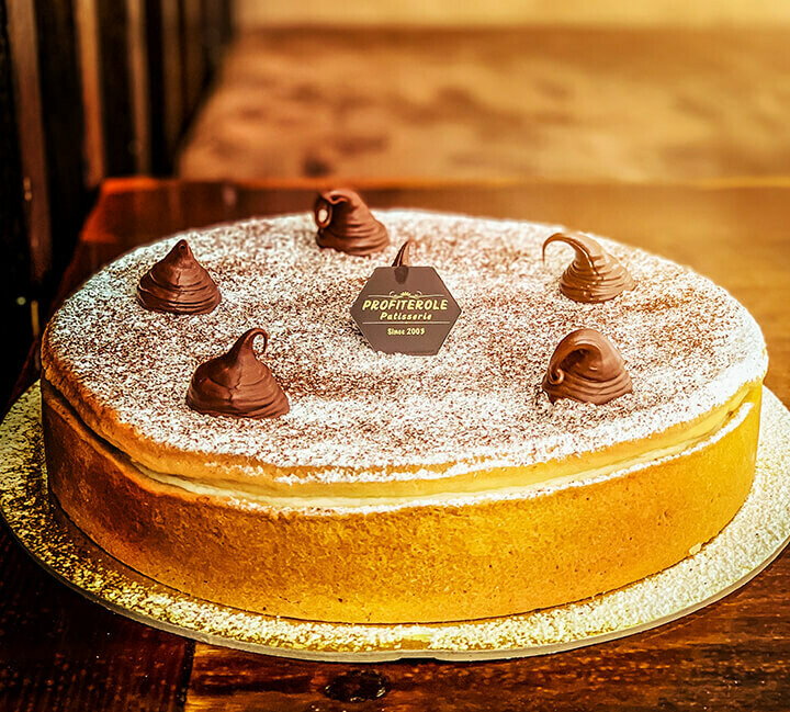 a baked ricotta cheesecake with nutella dashes and icing sugar on top